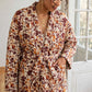  Kimono Flora à fleurs bordeaux et ocre sur fond écru, détail de la ceinture nouée et de la poche.