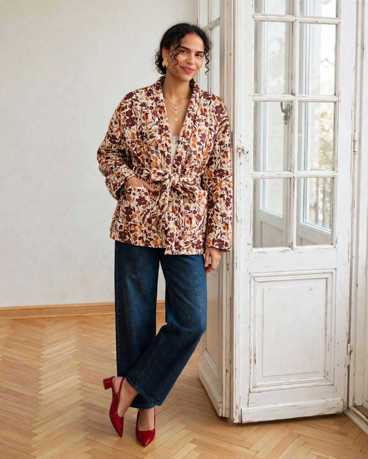  Kimono Flora porté ceinturé, main dans la poche, avec un jean bleu et des chaussures bordeaux.