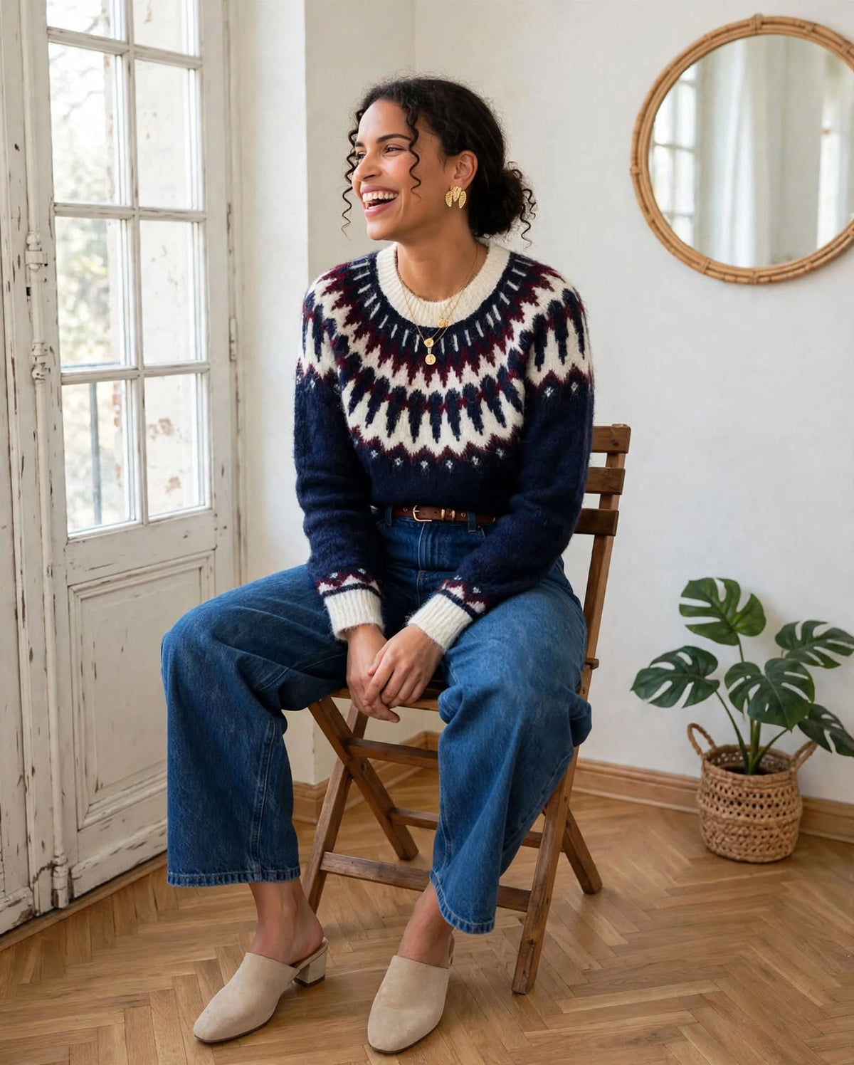 Pull Enora à motif jacquard porté avec un jean bleu, modèle assis sur une chaise.