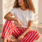 Pantalon large rayé rose et rouge en viscose et polyester, taille mi-haute avec cordon, par Esma Shop.