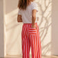 Pantalon large rayé rose et rouge en viscose et polyester, taille mi-haute élastiquée, par Esma Shop.