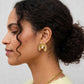 gros plan boucle oreille coquillage dore texture nacree