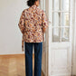 kimono Flora fleuri vu de dos, avec la ceinture à la taille et un jean bleu.